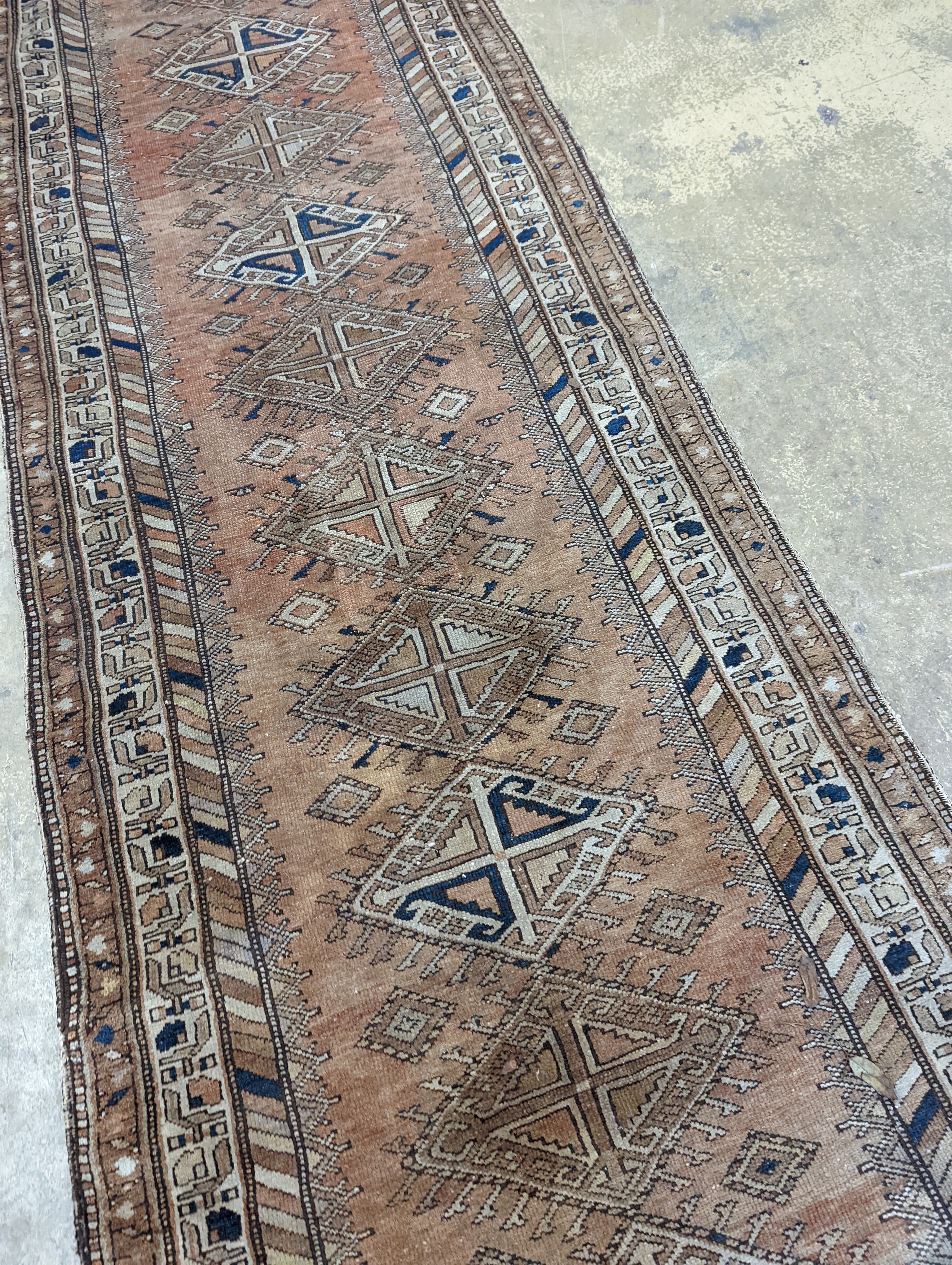 An antique Caucasian red ground runner, 372 x 106cm